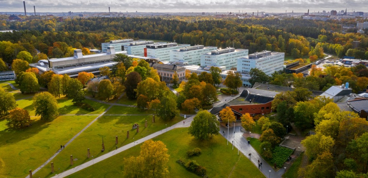 A drone view of Campus Frescati with Södra huset, green fields and trees in autumn colours..